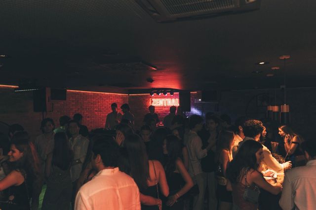 Pista de baile abarrotada en un club de paredes de ladrillo; al fondo, un neón rojo con el nombre Zentral.